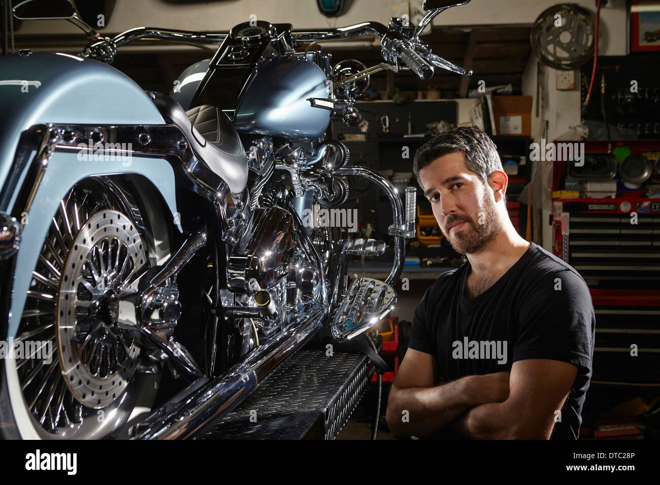 Portrait of mid adult man in motorcycle repair workshop Stock Photo