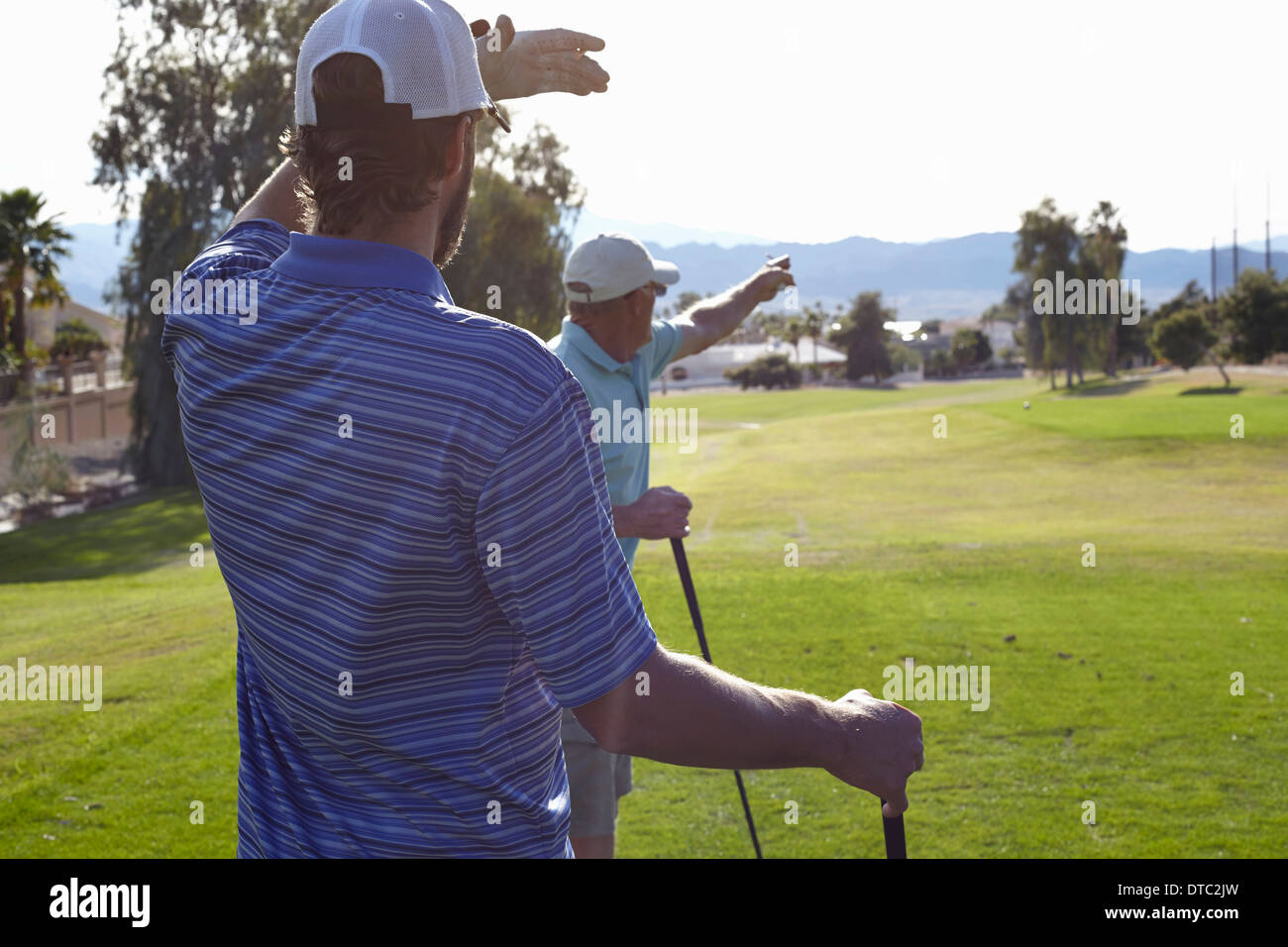 Two male golfers looking and pointing direction Stock Photo