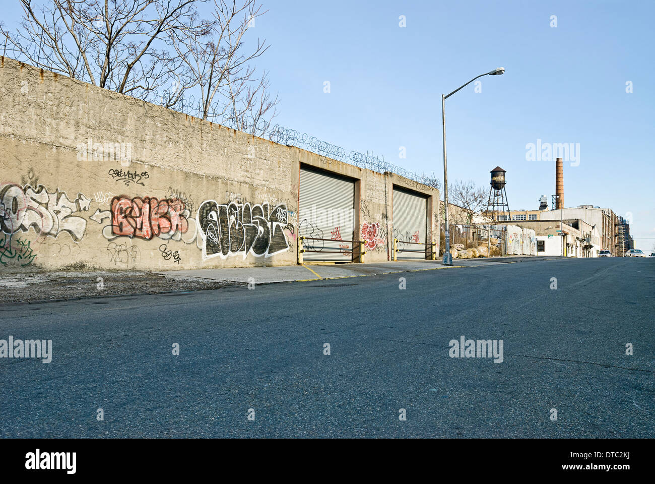 Deserted dangerous empty urban street scene with old warehouse buildings. Stock Photo