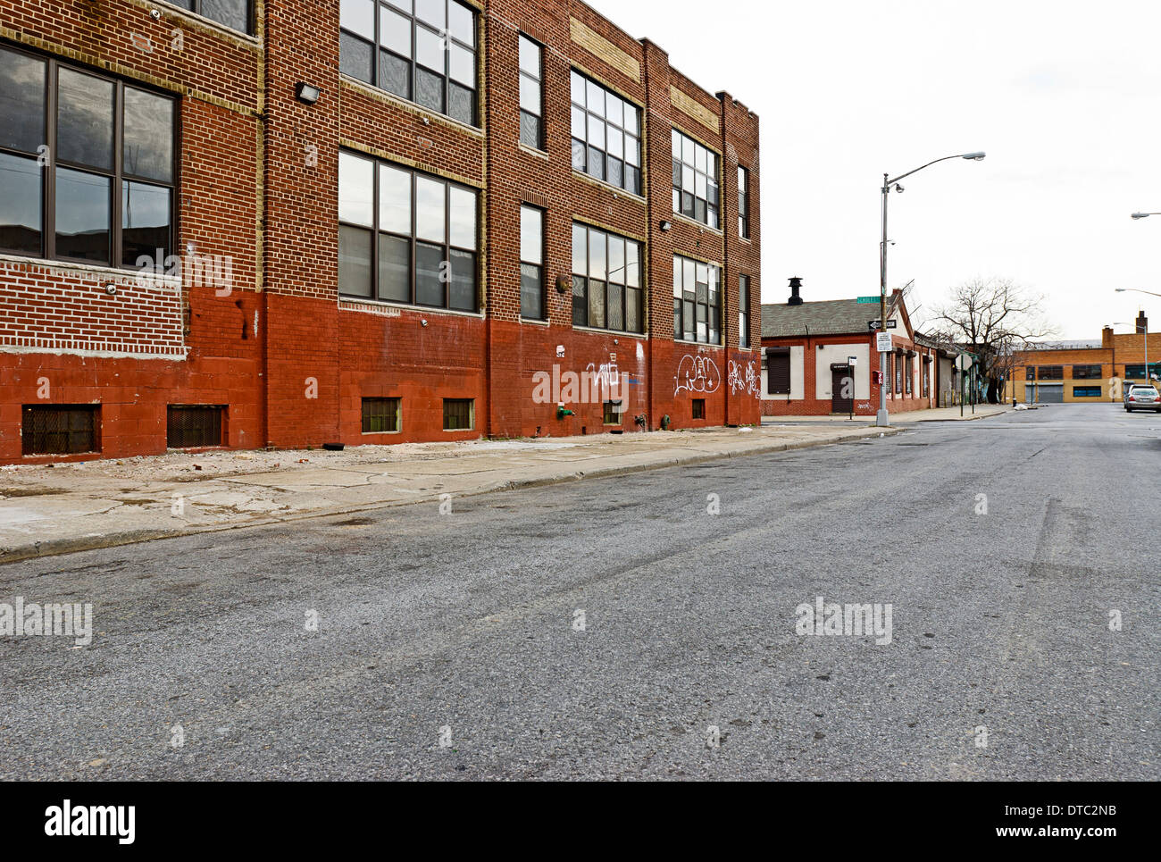 Deserted empty urban dangerous street scene with old warehouse buildings. Stock Photo