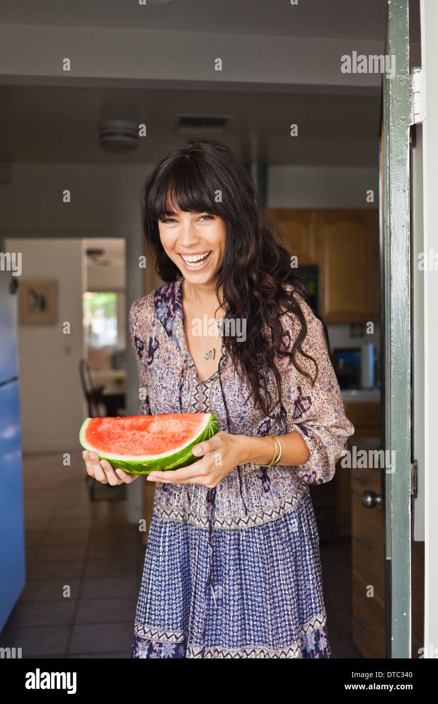 Young woman in doorway holding watermelon Stock Photo - Alamy