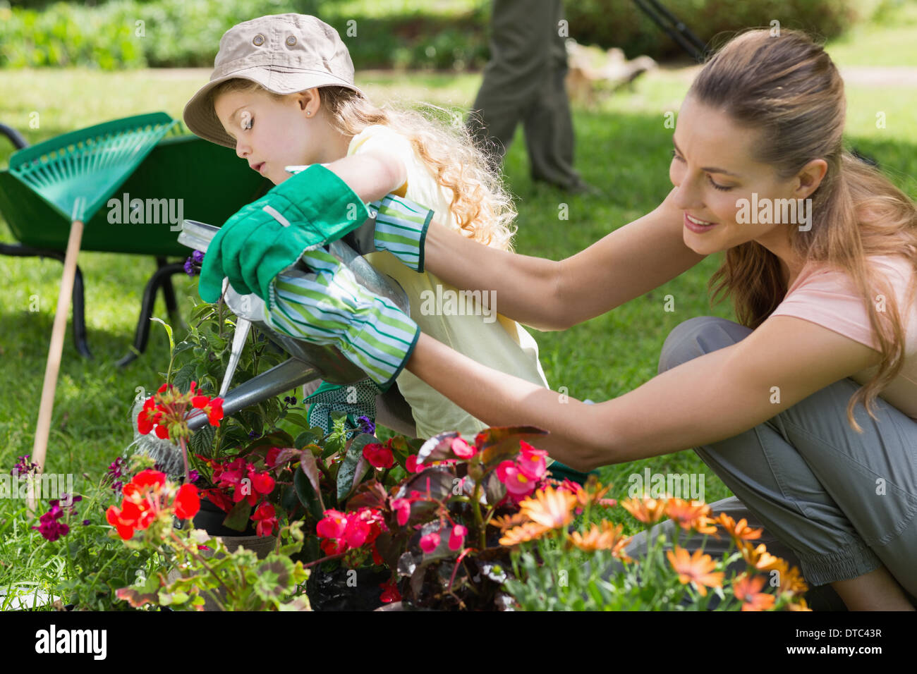 Mother and daughter watering plants at garden Stock Photo
