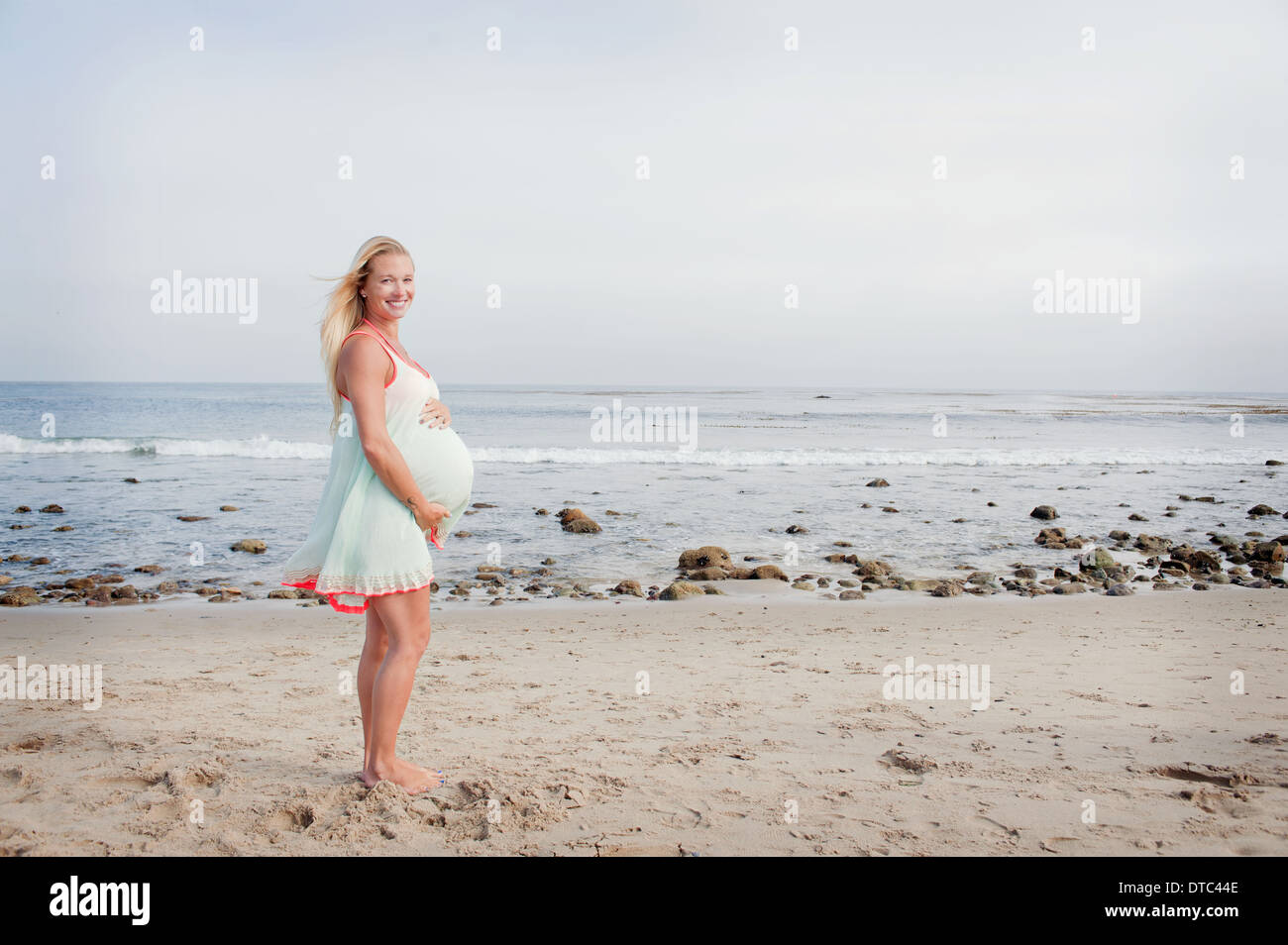 Portrait of pregnant young woman on beach Stock Photo