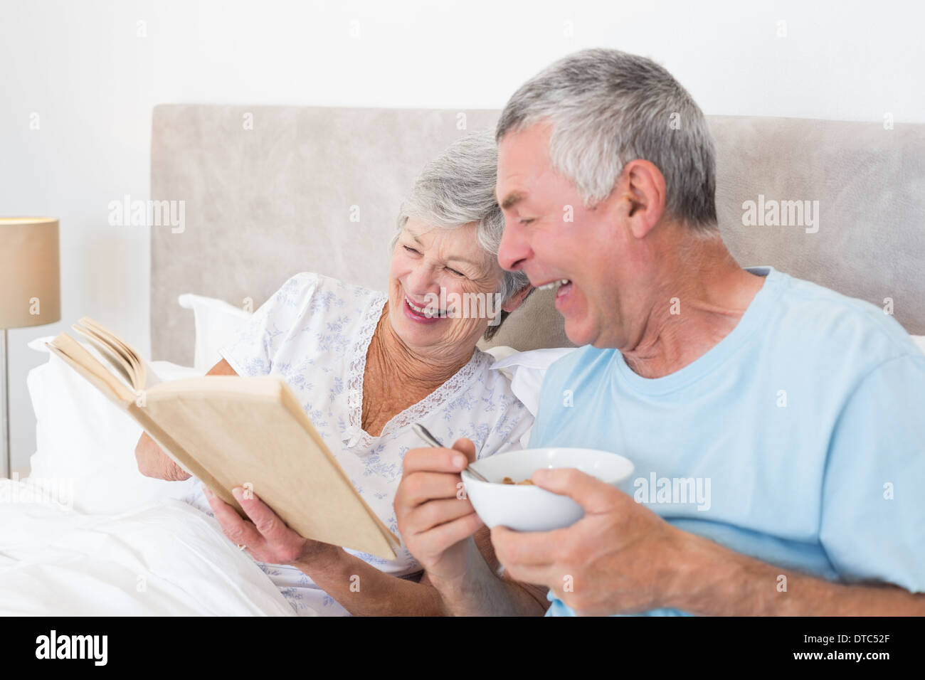 Senior couple reading book in bed Stock Photo