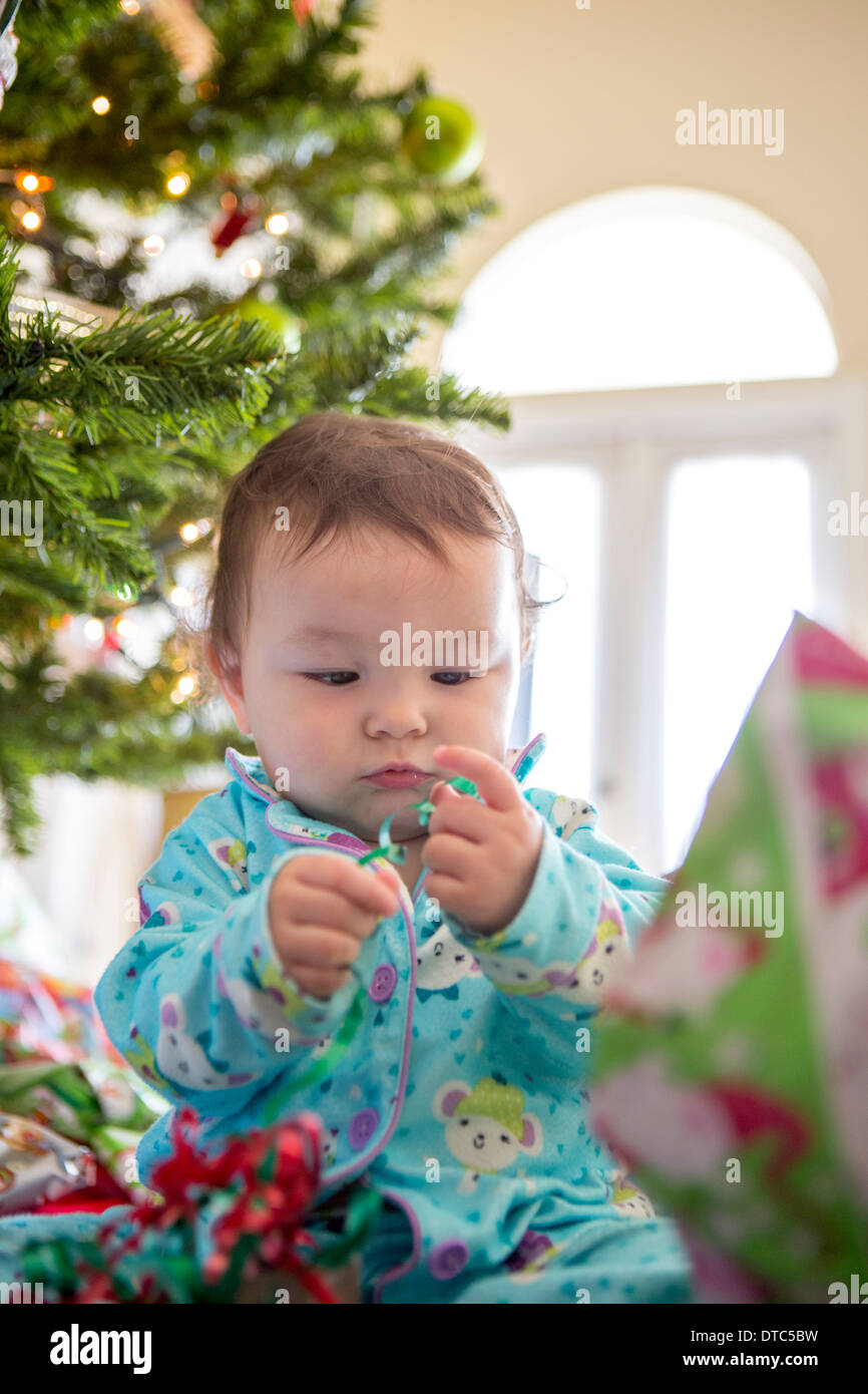 Baby girl opening christmas presents on her first Christmas Stock Photo