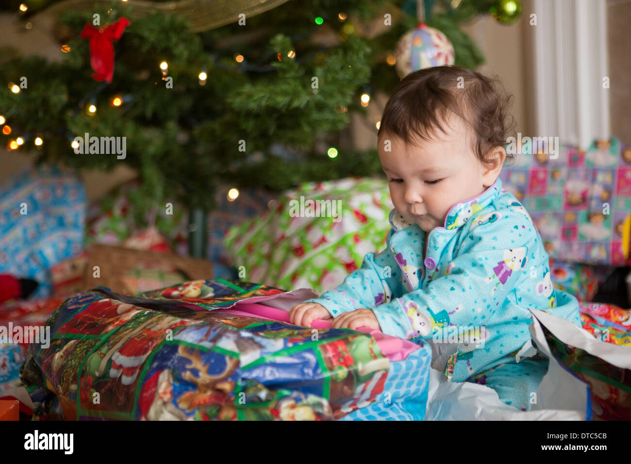 Baby girl opening presents on her first Christmas Stock Photo