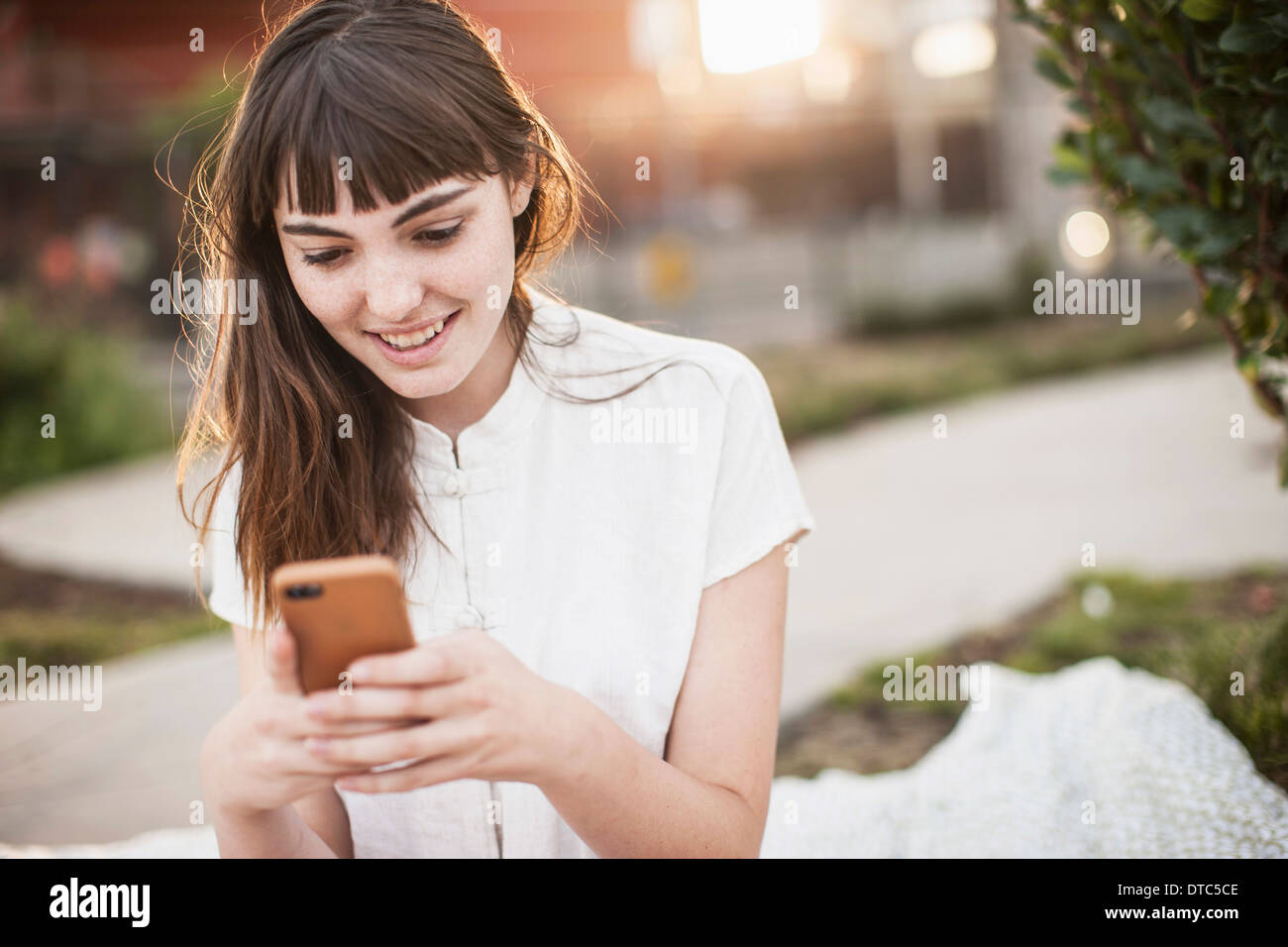 Young woman texting on cellphone Stock Photo