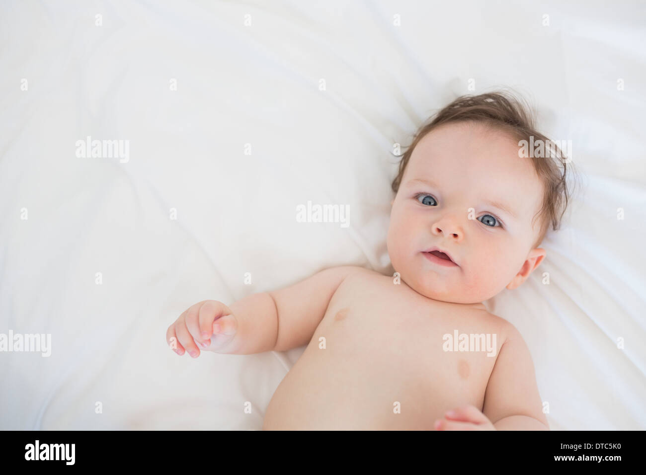 Portrait of lovely baby lying in bed Stock Photo
