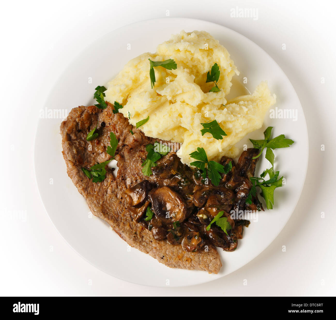 Top view of a meal of a fried veal escalope with sauteed mushrooms and mashed potatoes. Stock Photo