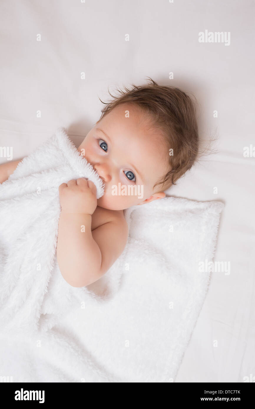 Cute baby holding blanket in crib Stock Photo