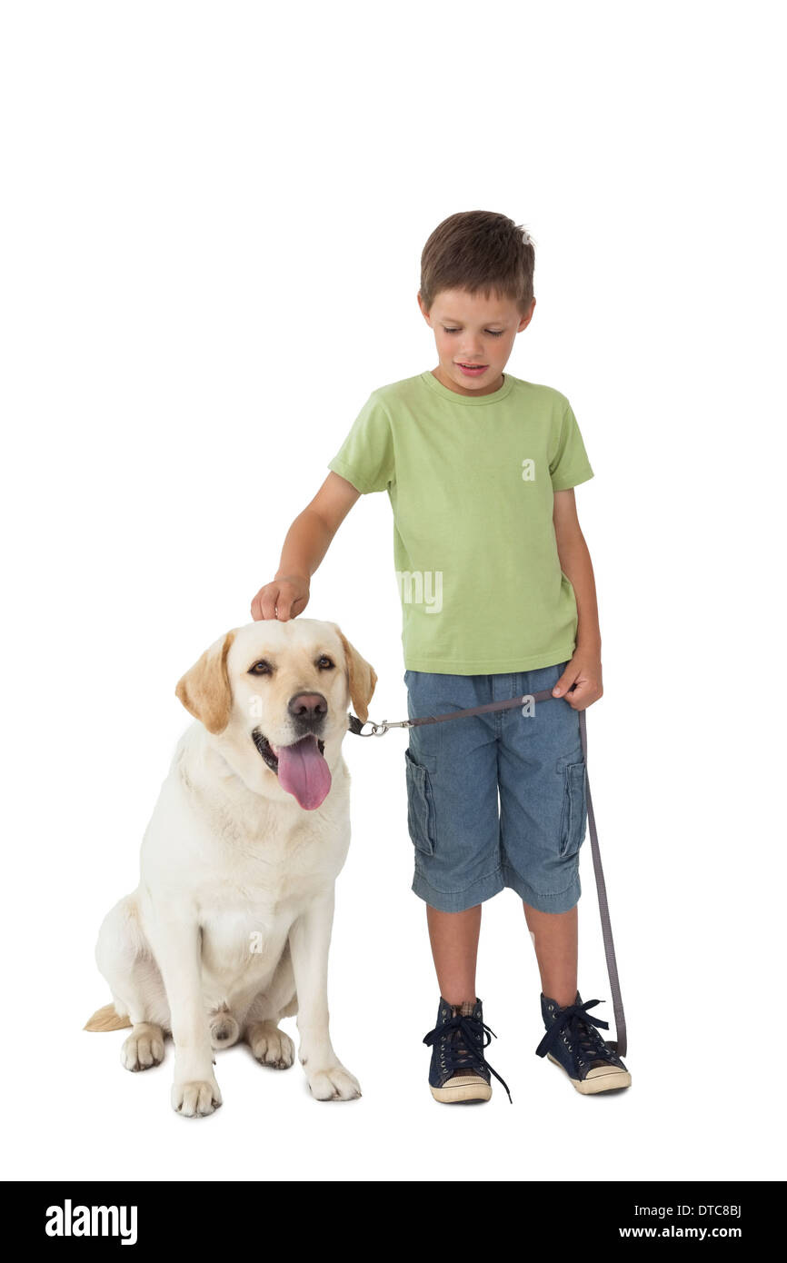 Cute little boy standing with his labrador dog Stock Photo