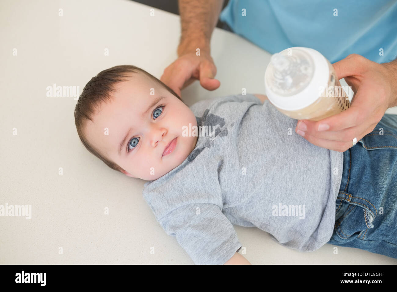 Innocent baby with father feeding milk Stock Photo