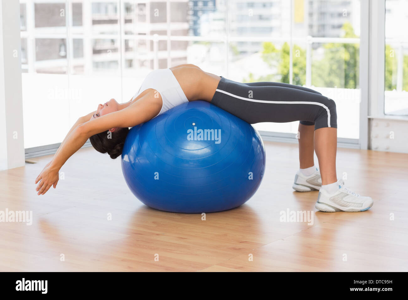 Fit woman stretching on exercise ball at gym Stock Photo - Alamy