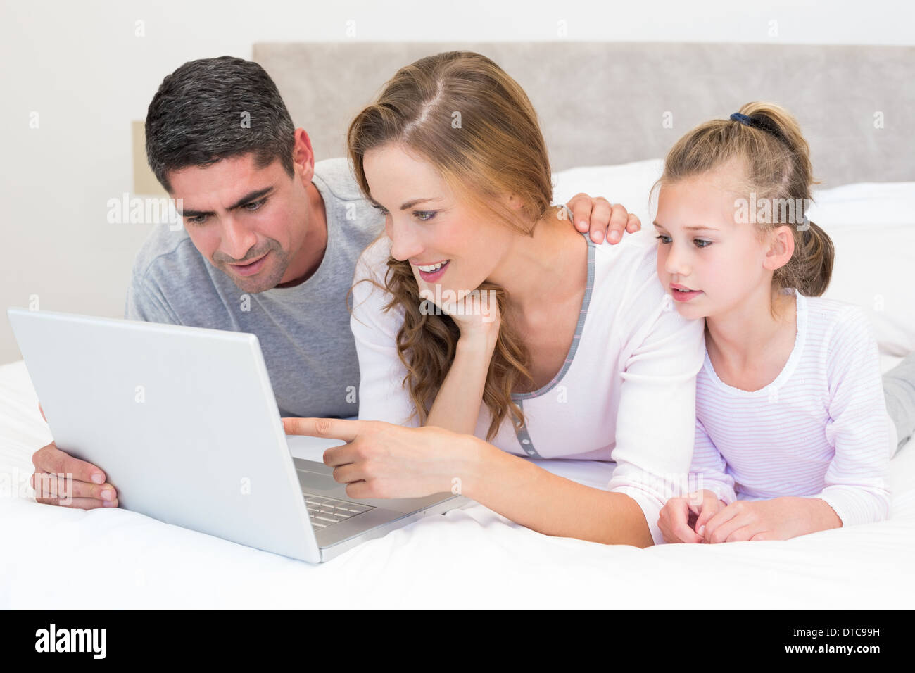 Family using laptop in bed Stock Photo