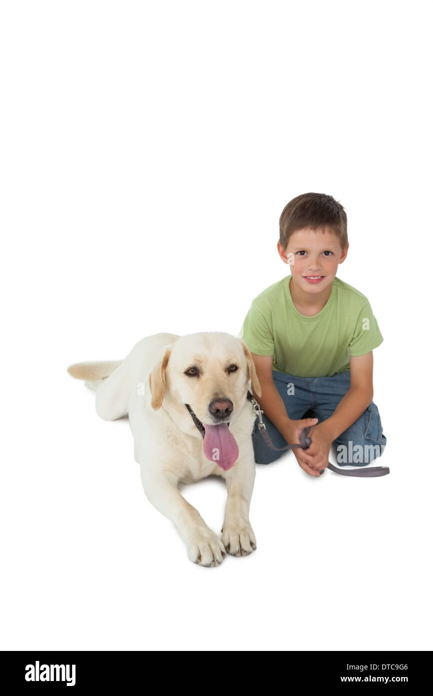 Cute little boy kneeling with his labrador dog smiling at camera Stock Photo