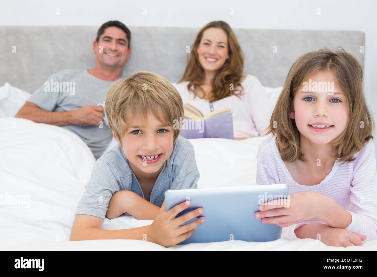 Smiling siblings holding digital tablet Stock Photo