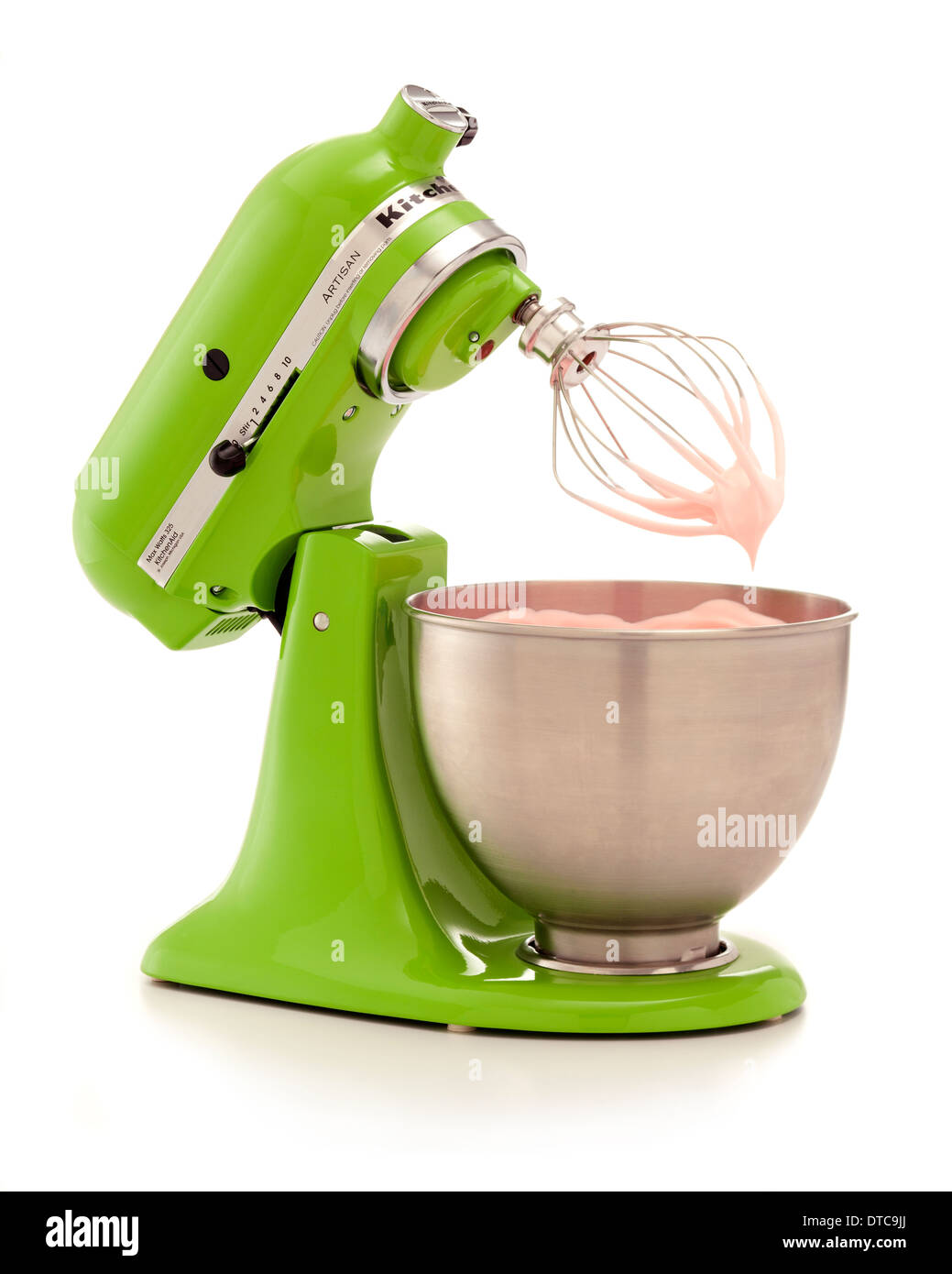 Green kitchenaid mixer with a bowl of pink icing that was just made on a white background Stock Photo