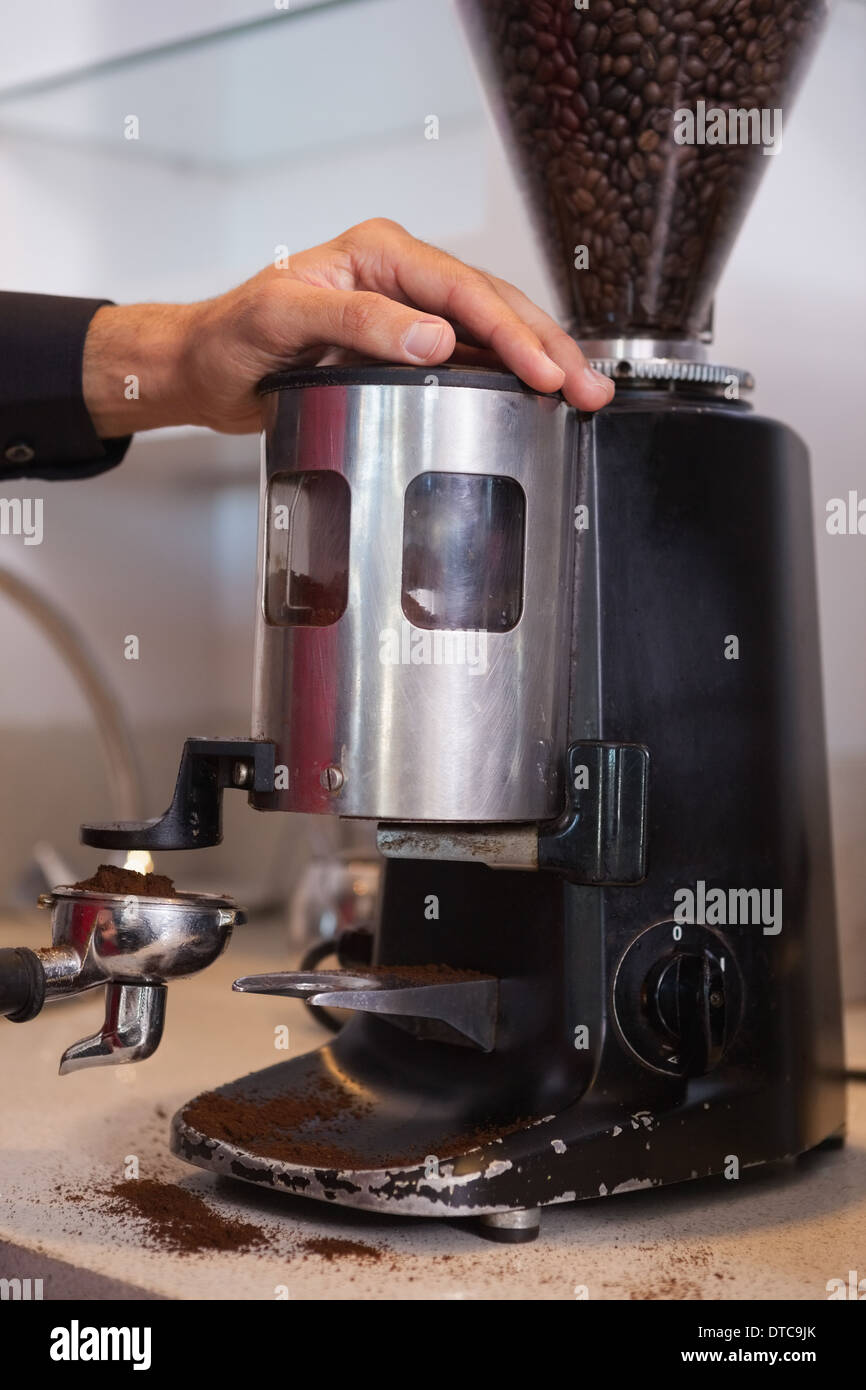 Barista using coffee grinder to grind beans Stock Photo Alamy