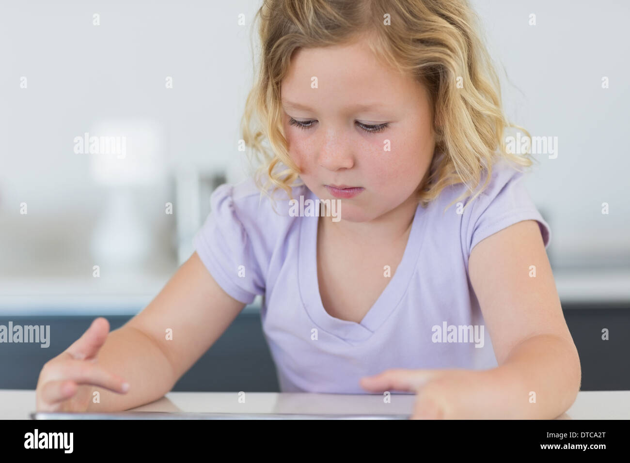 Girl using digital tablet at table Stock Photo