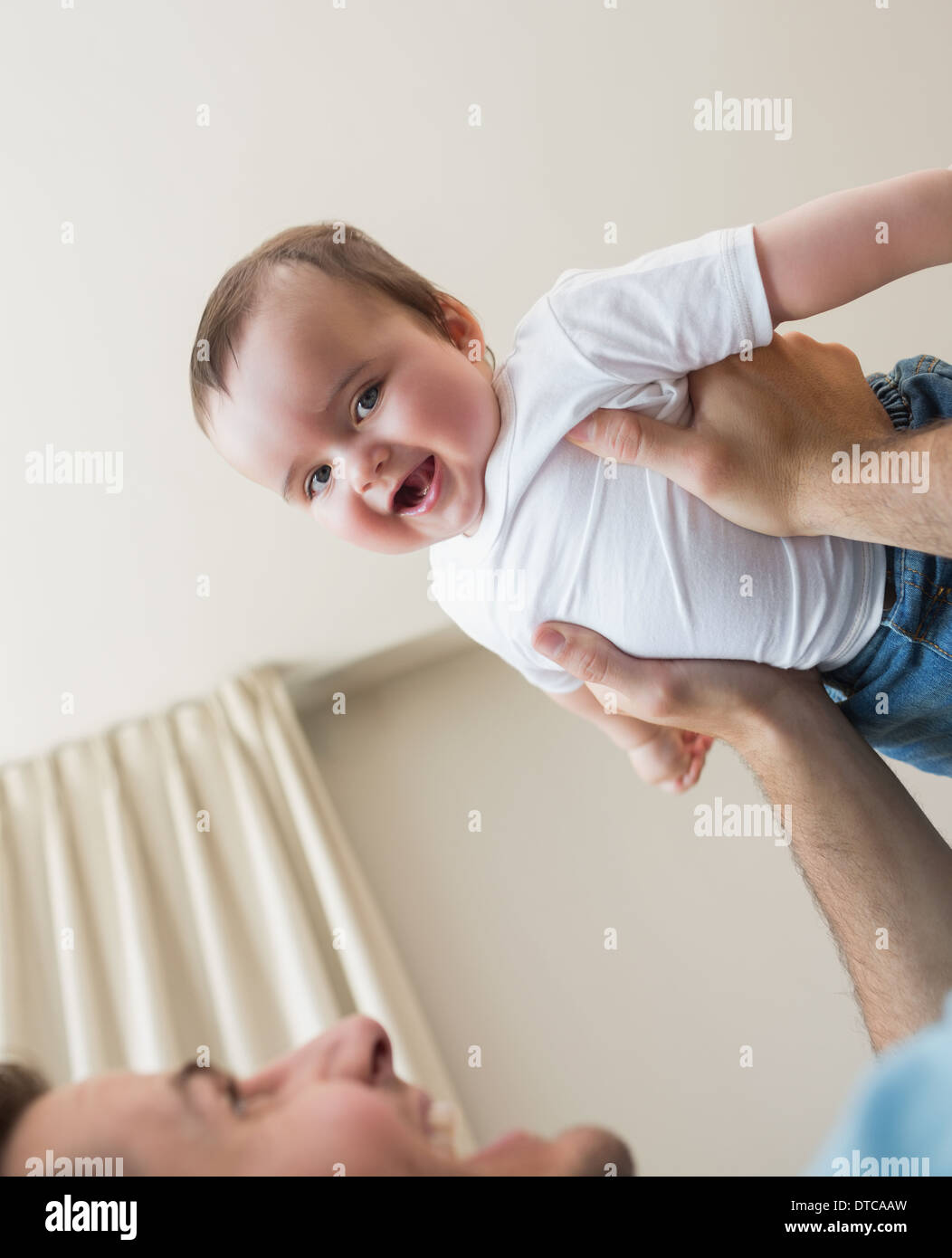 cheerful baby being carried by father Stock Photo