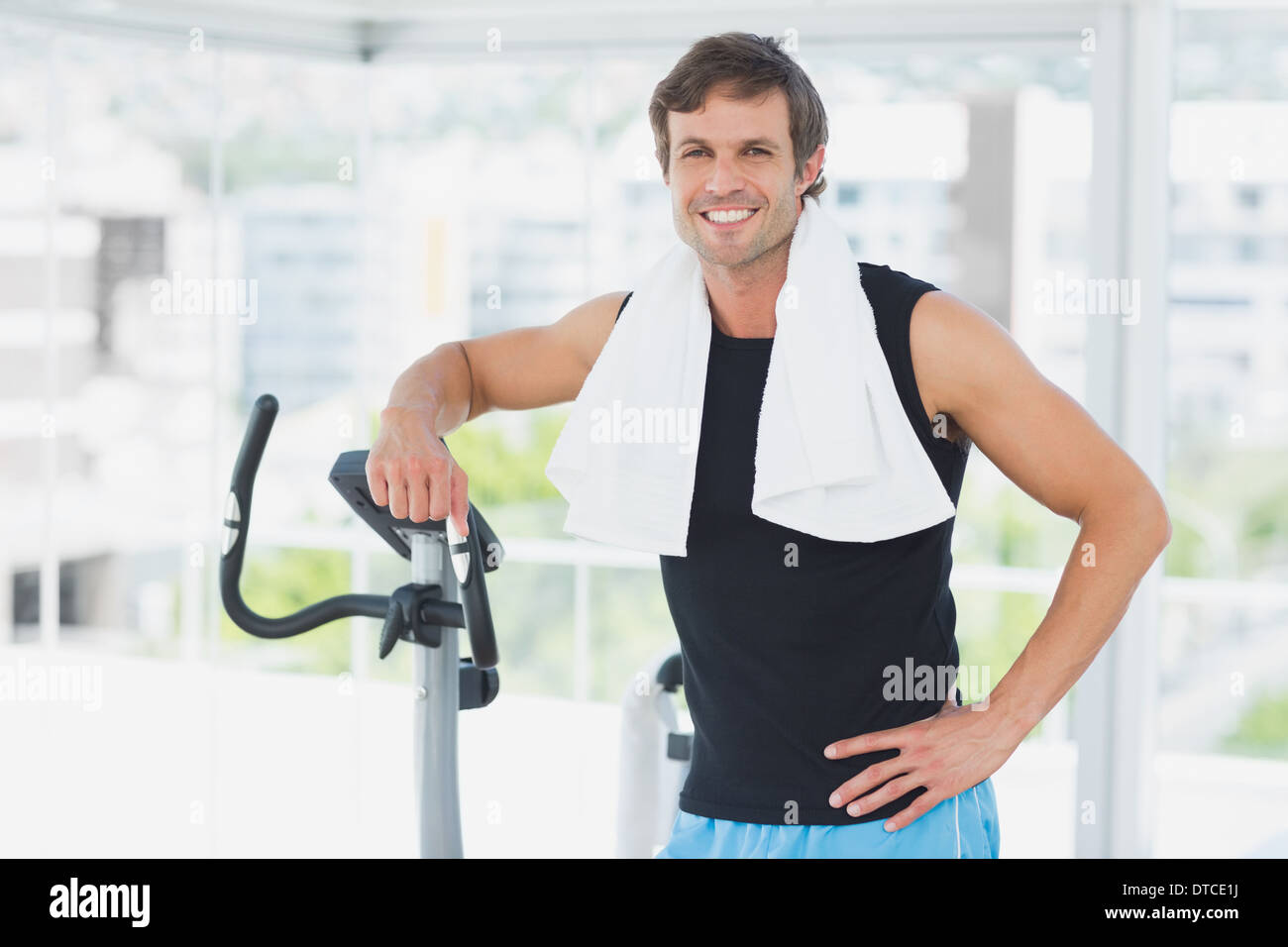 Smiling man standing at spinning class in bright gym Stock Photo - Alamy