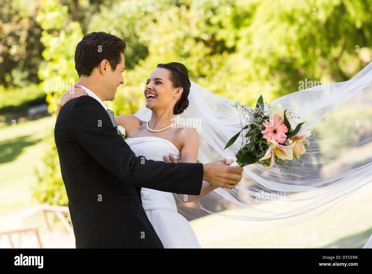 Cheerful newlywed couple dancing in park Stock Photo - Alamy