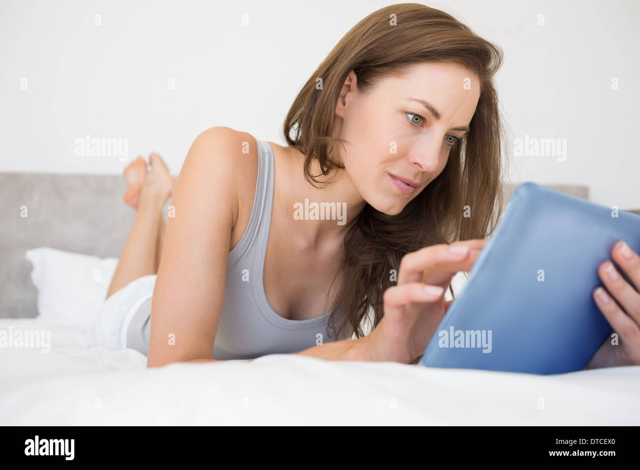 Pretty relaxed woman reading book in bed Stock Photo