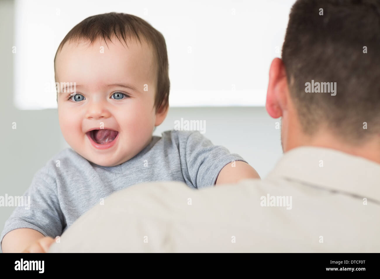 Cheerful baby being carried by father Stock Photo