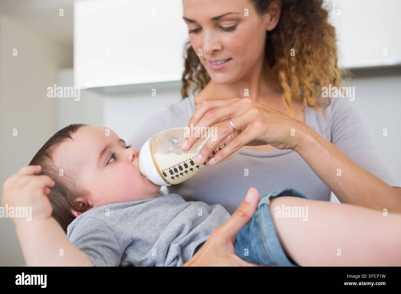 Mother feeding milk to cute baby Stock Photo