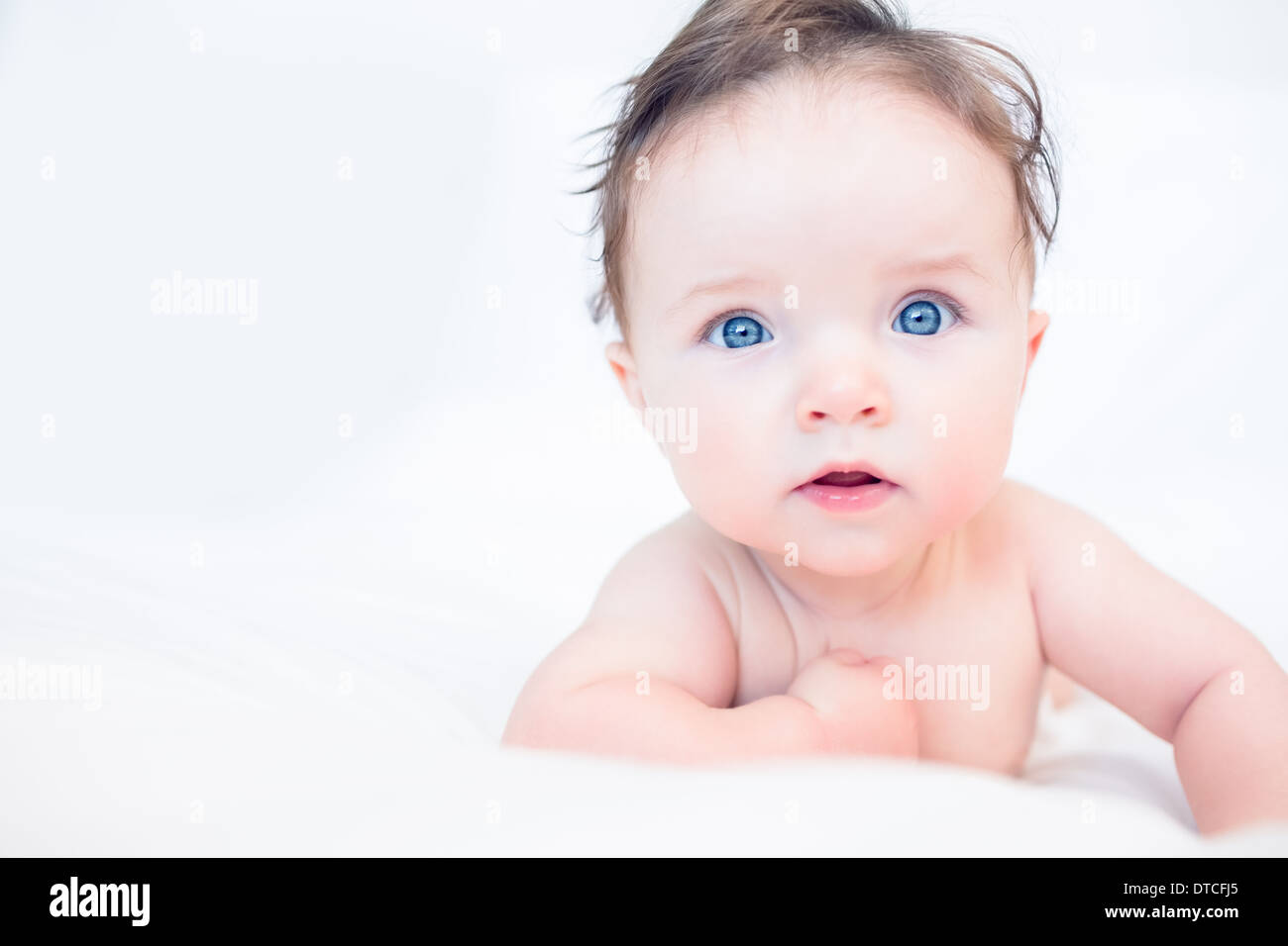 Lovely baby with blue eyes in bed Stock Photo