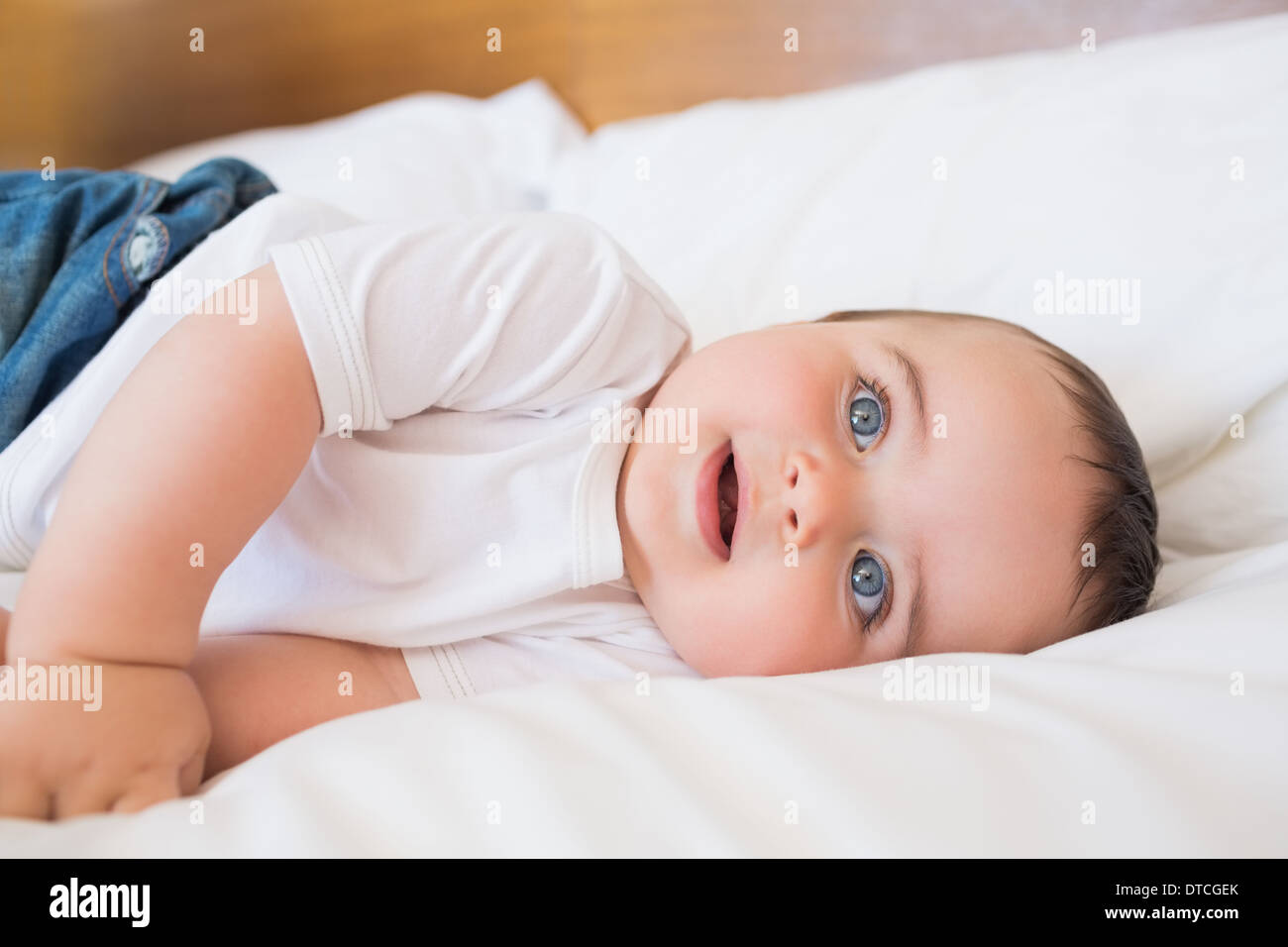 Baby lying in bed Stock Photo