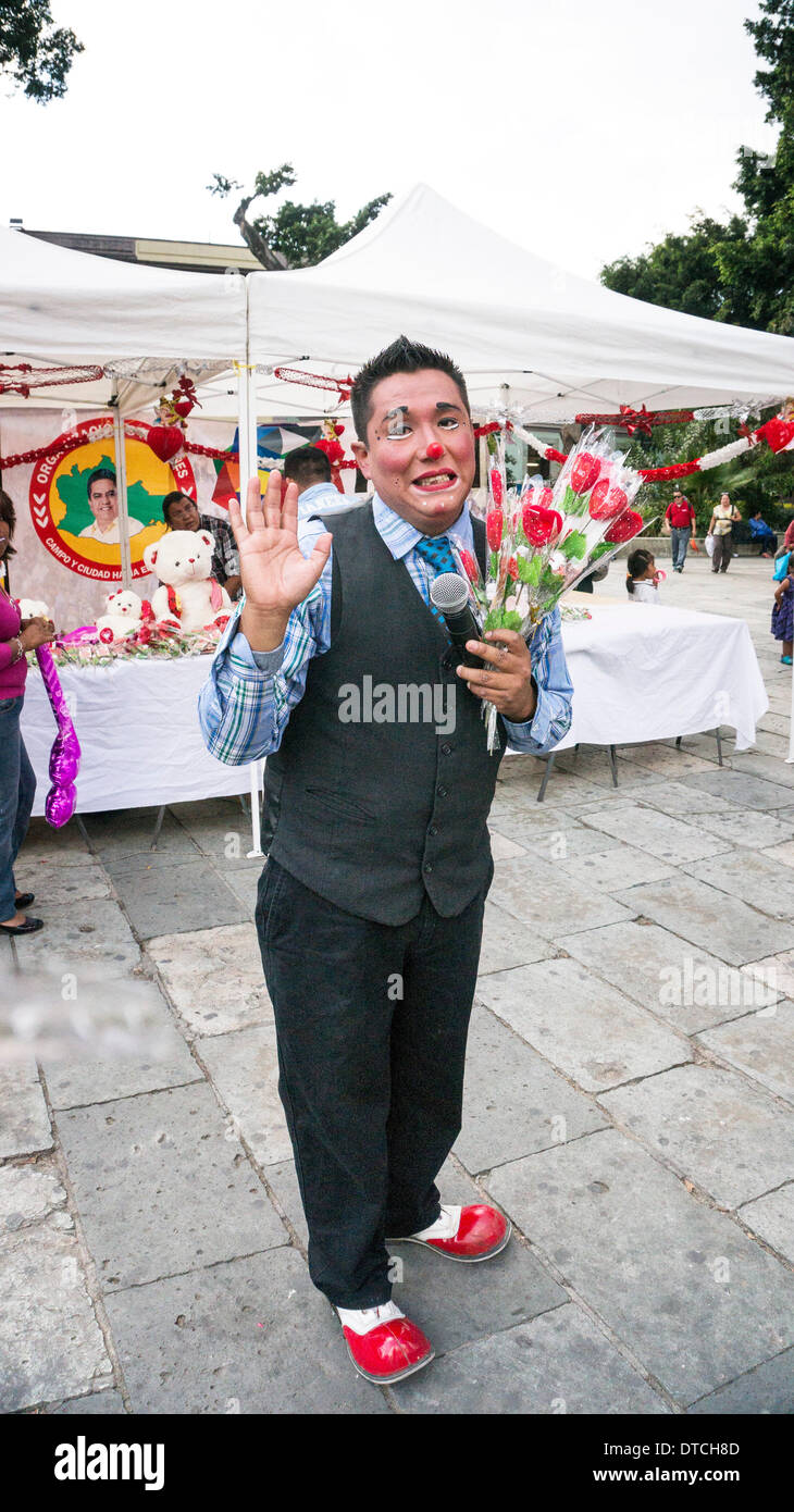 Oaxaca, Mexico; February 14, 2014: man in clown costume distributes free hearts wrapped in cellophane in front of political candidate's booth on Valentines day Credit:  Dorothy Alexander/Alamy Live News Stock Photo