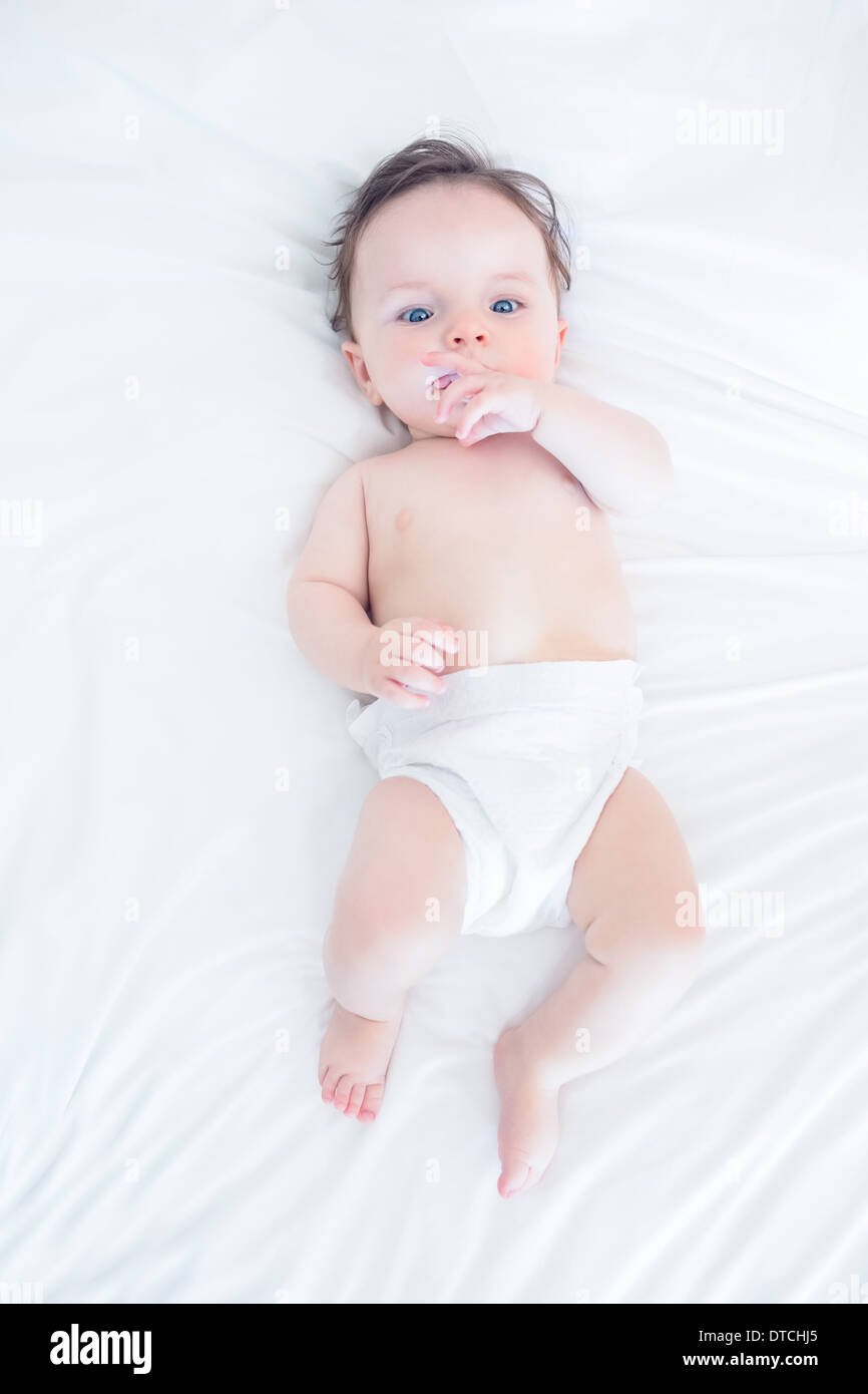 Innocent baby with finger in mouth Stock Photo