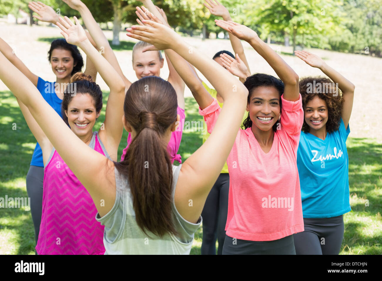 Women performing fitness dance with instructor at park Stock Photo