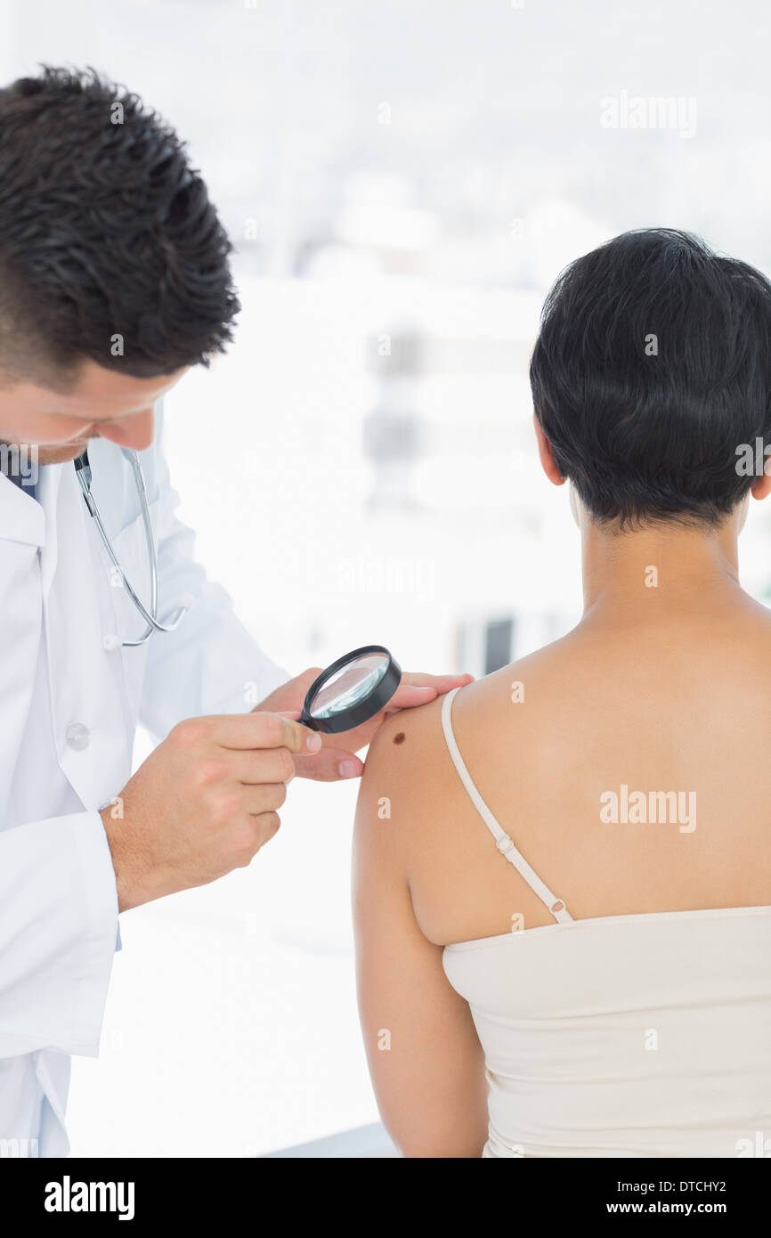 Dermatologist examining mole on woman Stock Photo Alamy