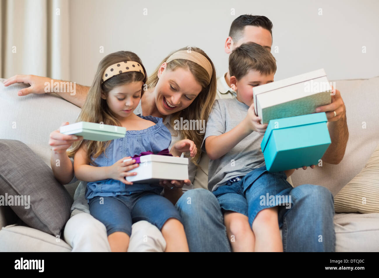 Family opening gifts on sofa Stock Photo