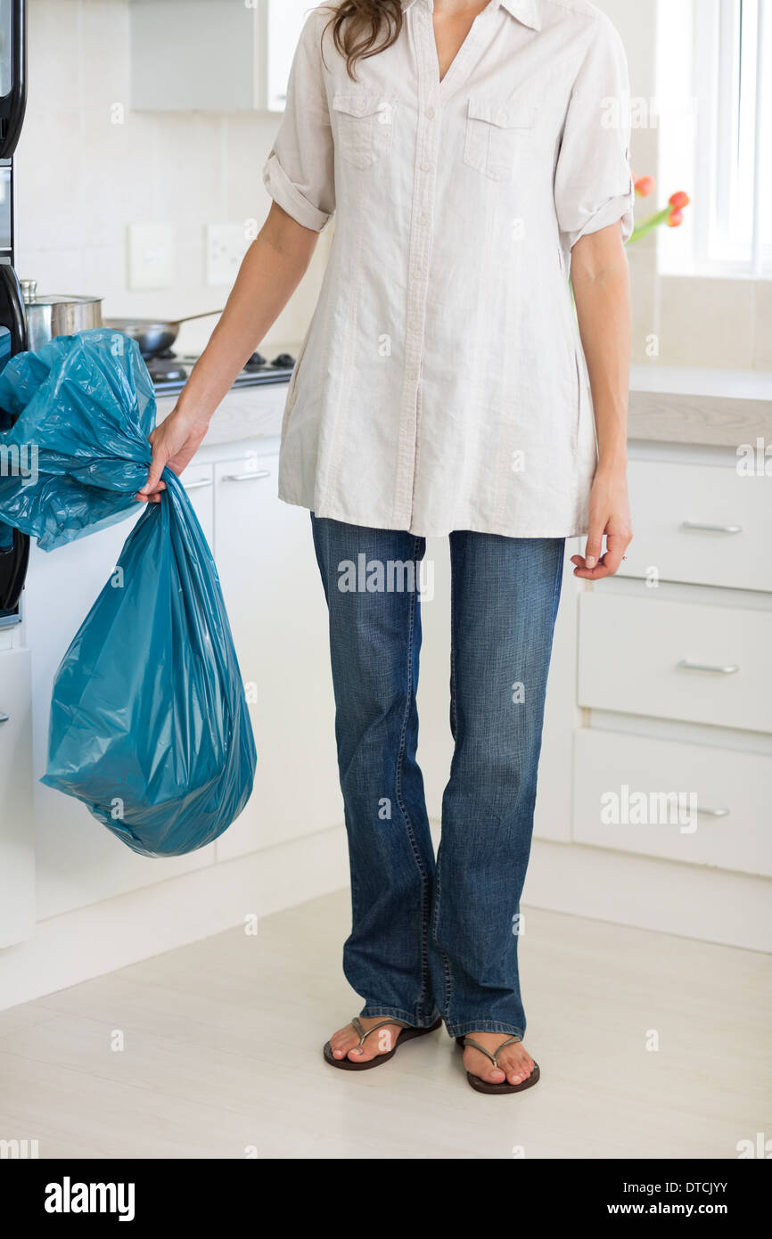 Low section of woman carrying garbage bag in kitchen Stock Photo Alamy