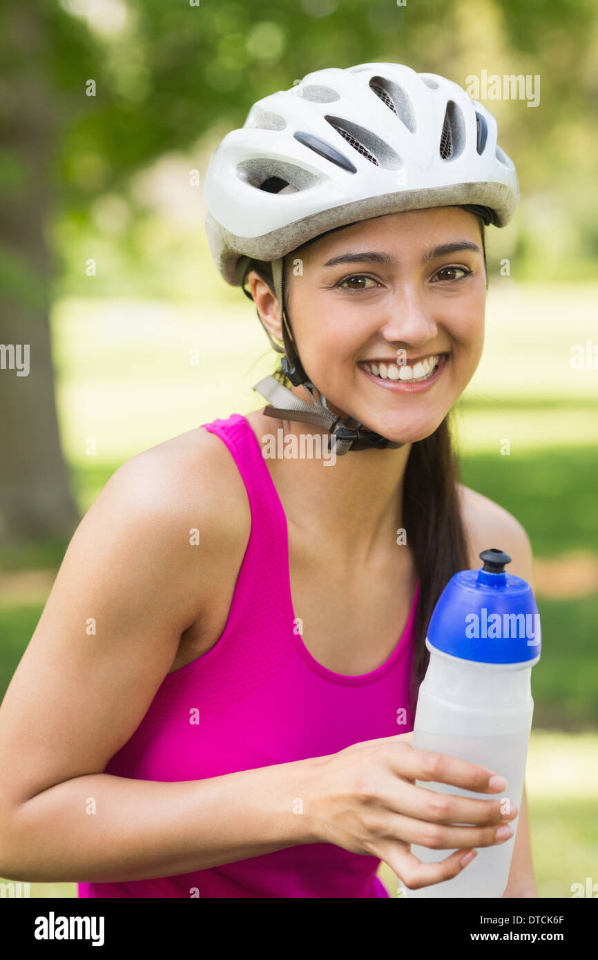 Fit woman in helmet holding water bottle at park Stock Photo Alamy