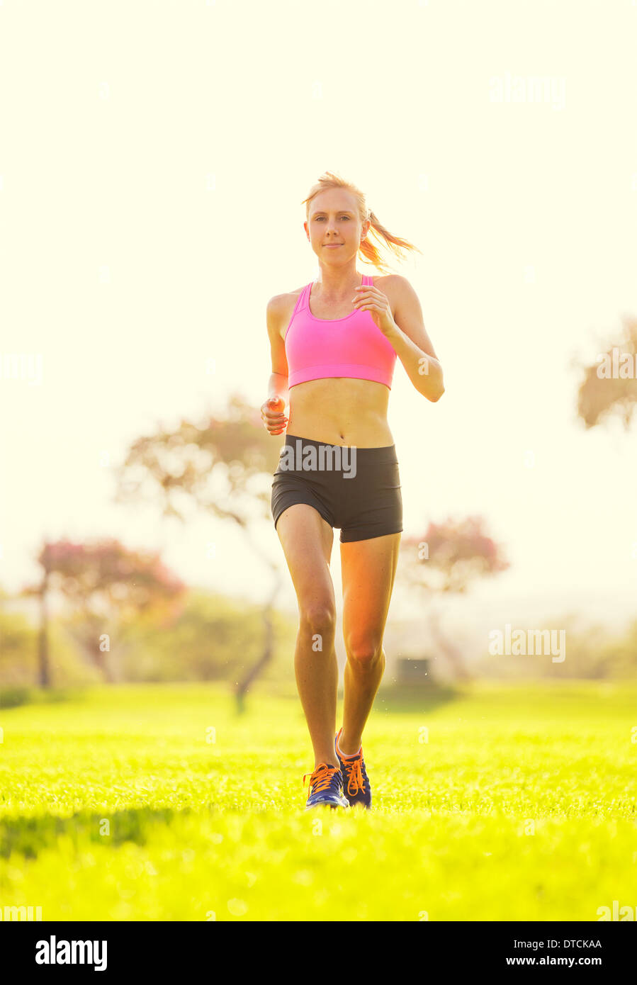 Attractive young woman jogging at sunrise. Running on Park Trail in the