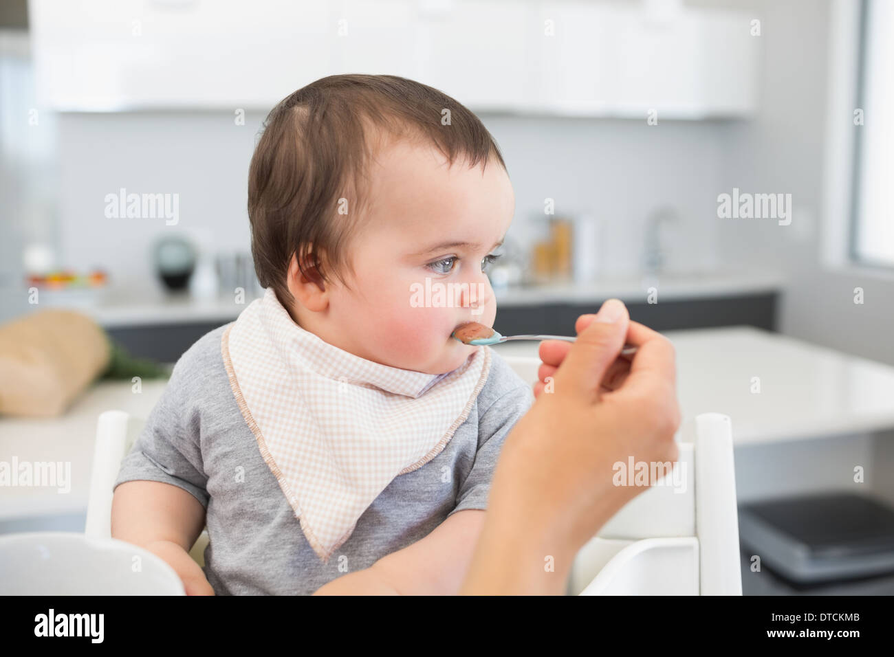Adorable baby being fed by mother Stock Photo