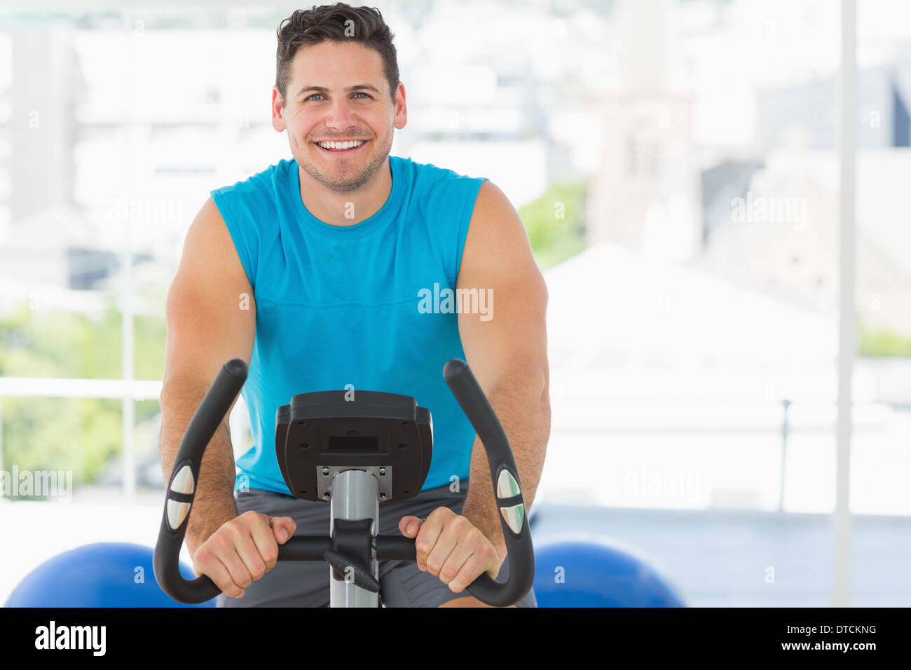 Smiling young man working out at spinning class Stock Photo