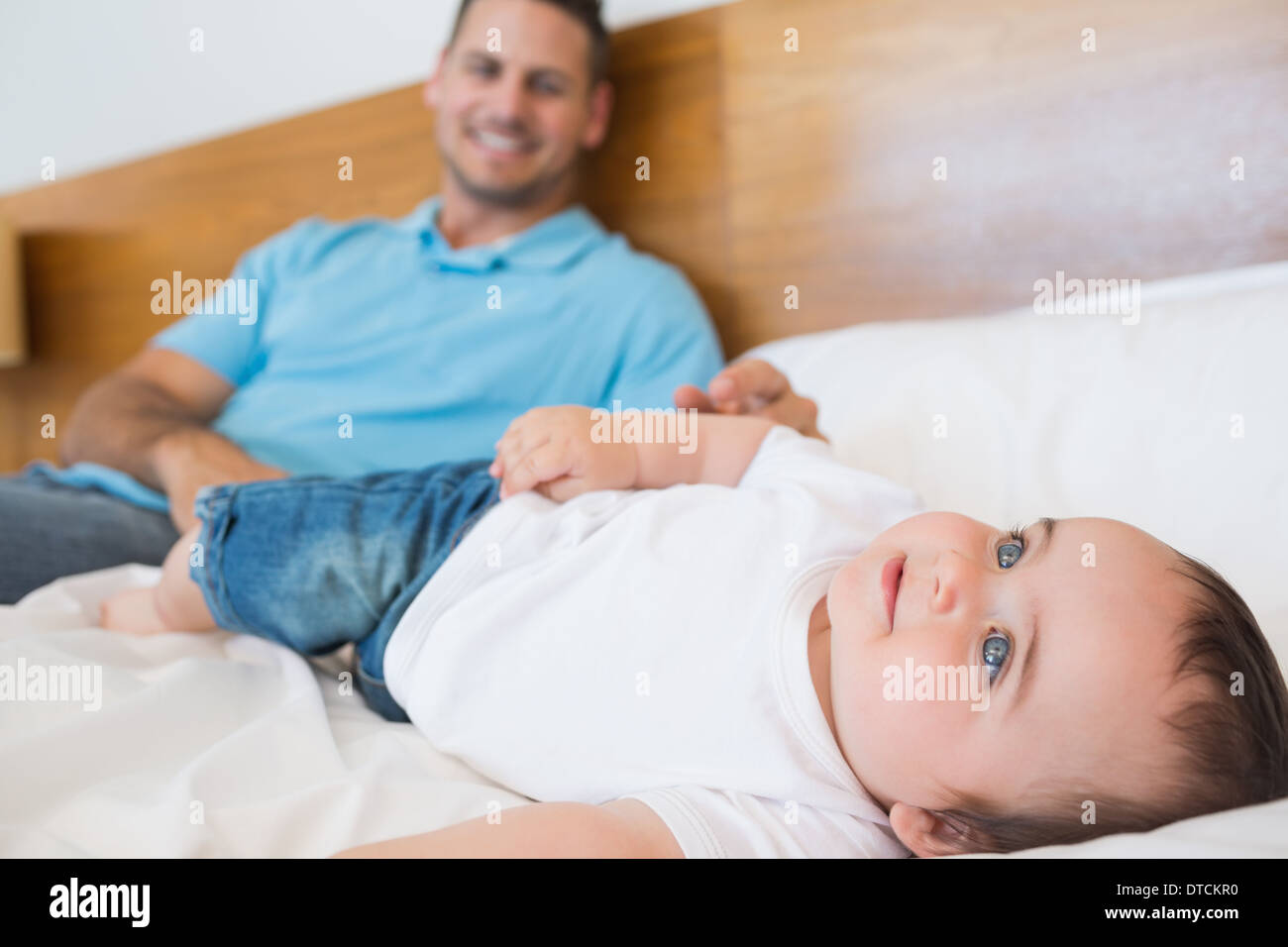 Smiling baby lying on bed Stock Photo