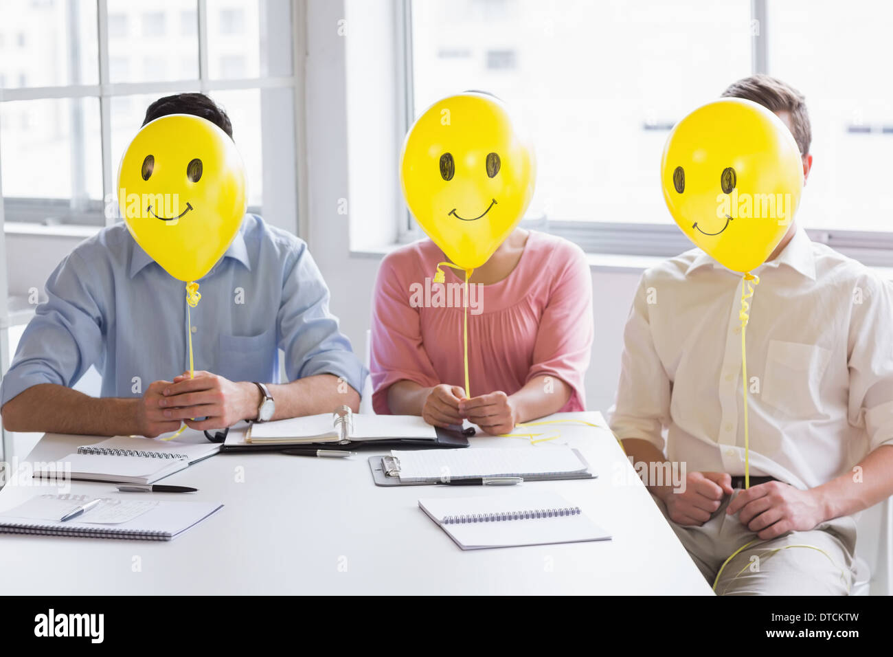 Business people holding balloons in front of face Stock Photo