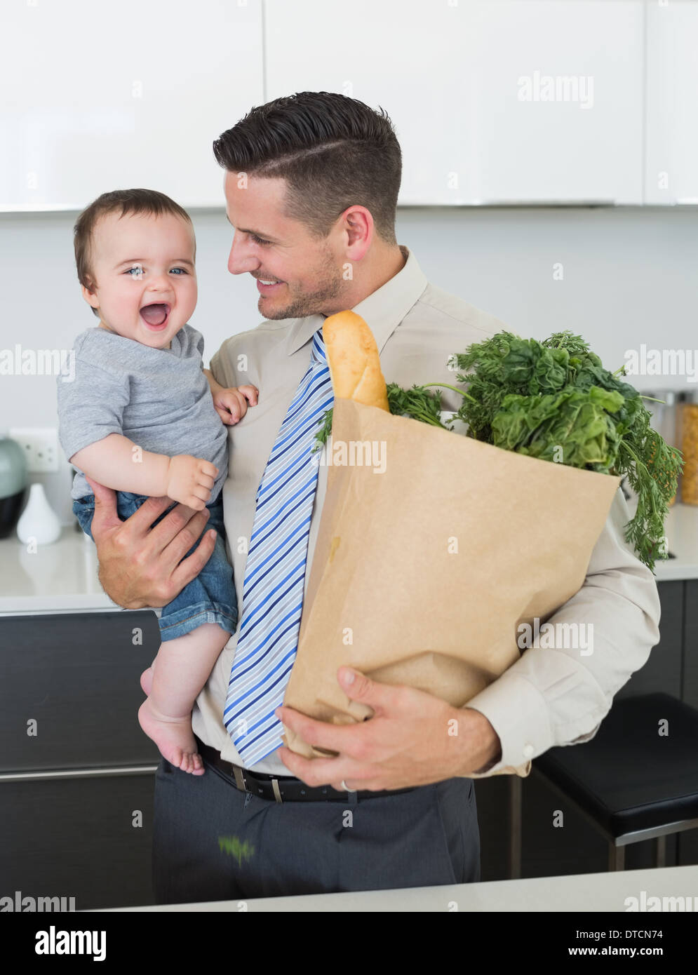 Businessman with grocery carrying baby Stock Photo Alamy