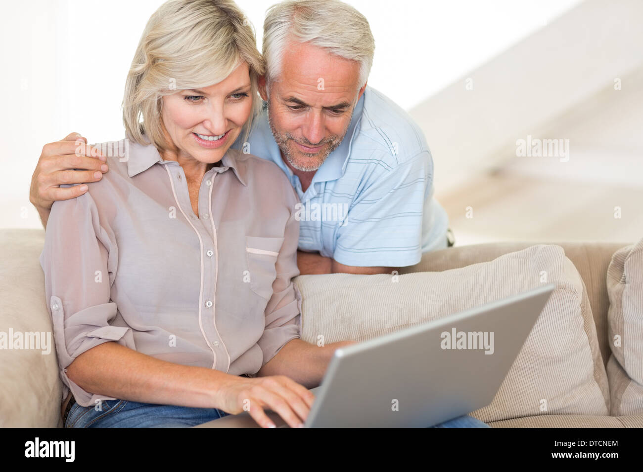 Mature couple using laptop on sofa Stock Photo