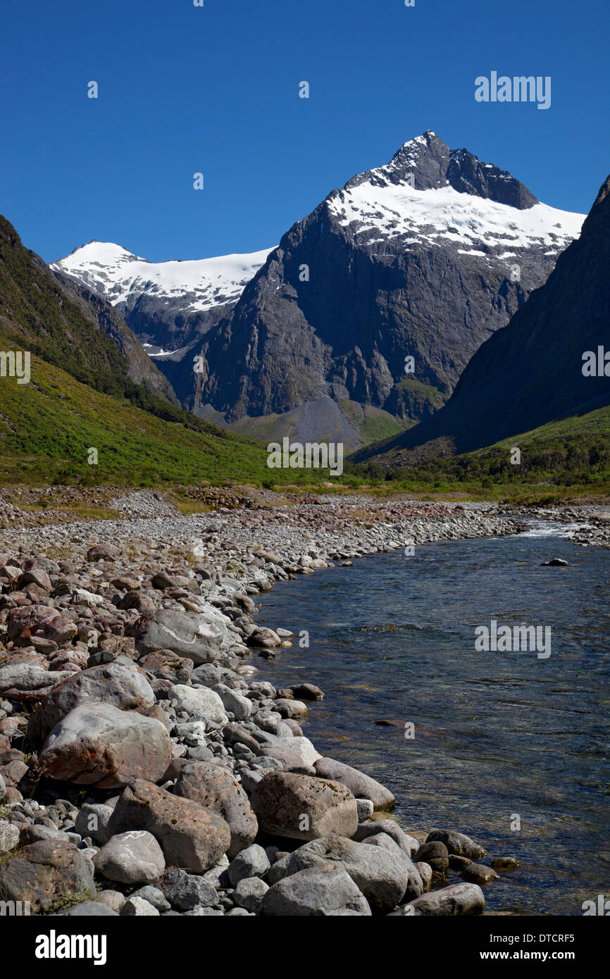 View along river towards Mount Christina on road to Milford Sound, Fiordland, South Island, New Zealand Stock Photo