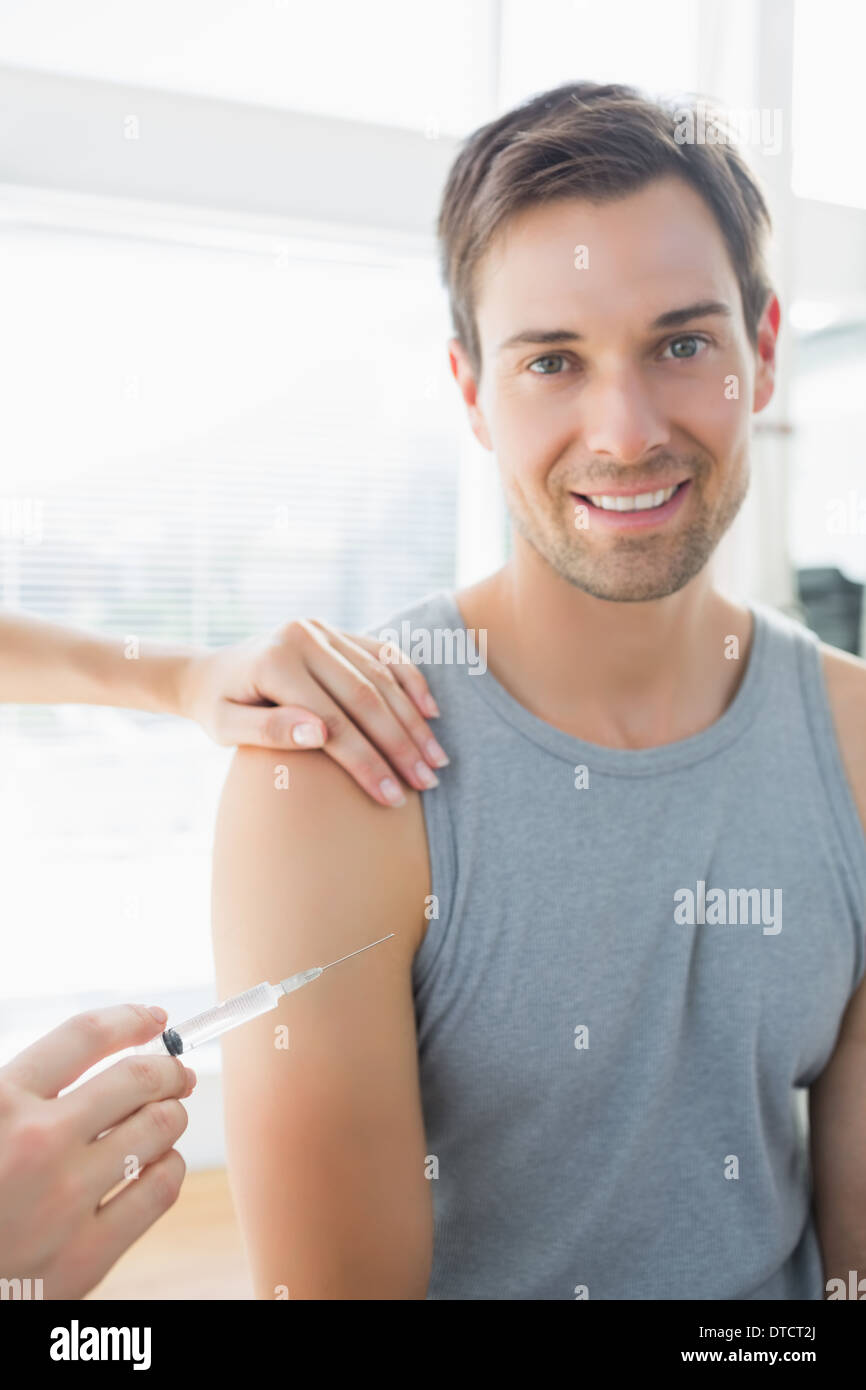 Happy man being injected by doctor Stock Photo