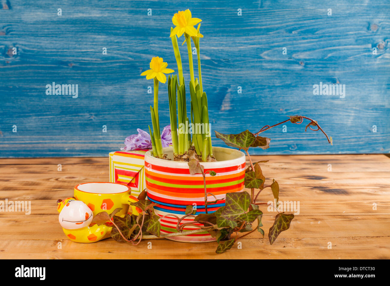 Easter decoration with daffodils in pot and Easter basket, porcelain turtle Stock Photo