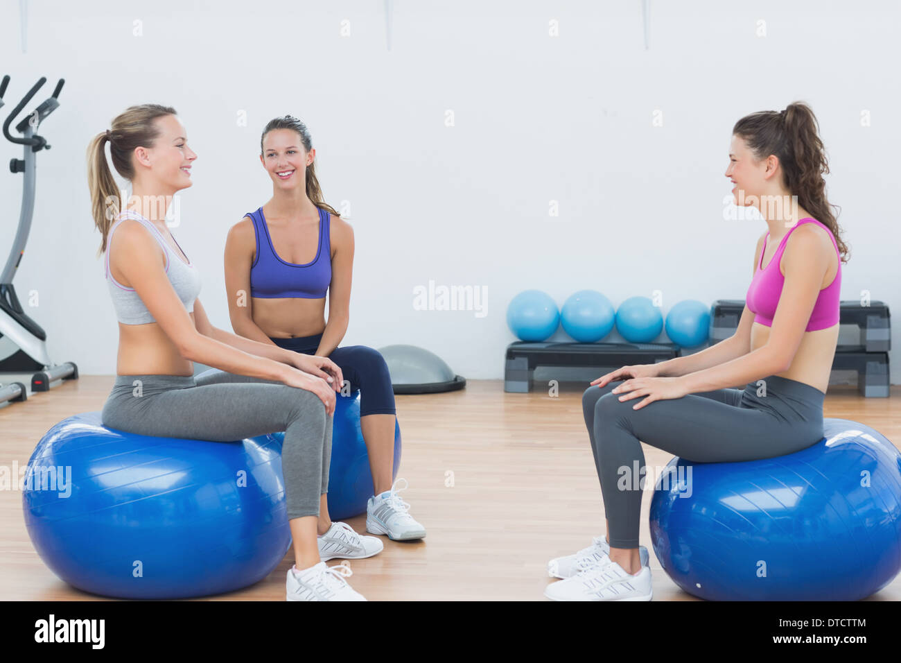 Sporty young women sitting on exercise balls Stock Photo - Alamy