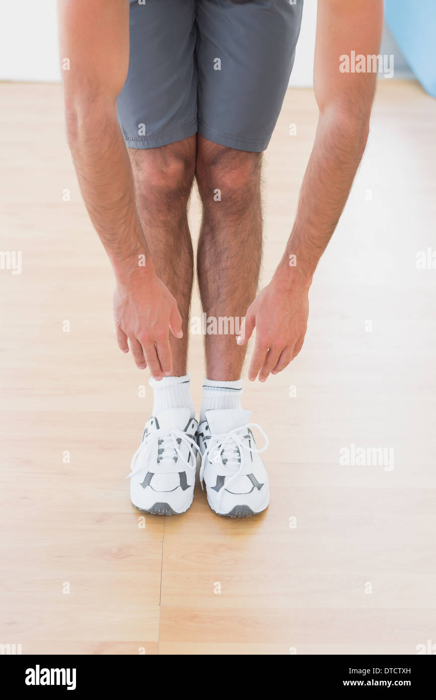 Man touching hands to feet in fitness studio Stock Photo